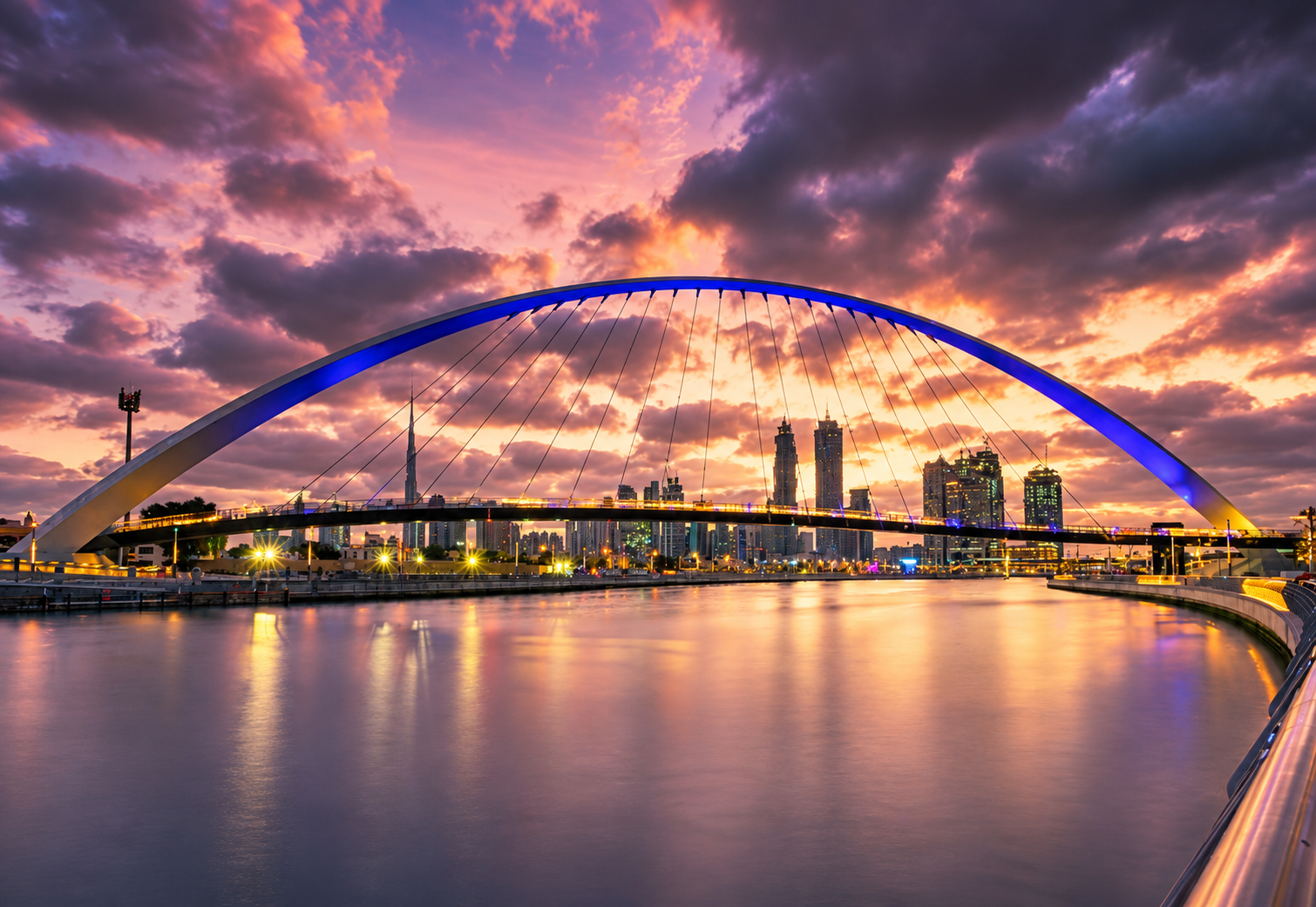 Dubai Water Canal Tolerance Bridge and city skyline at twilight